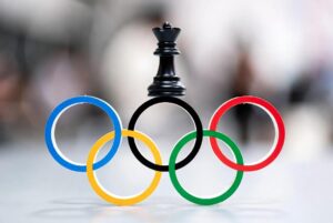 Alt text: "Intense chess match between expert players at the Olympics, exuding focus and strategy."